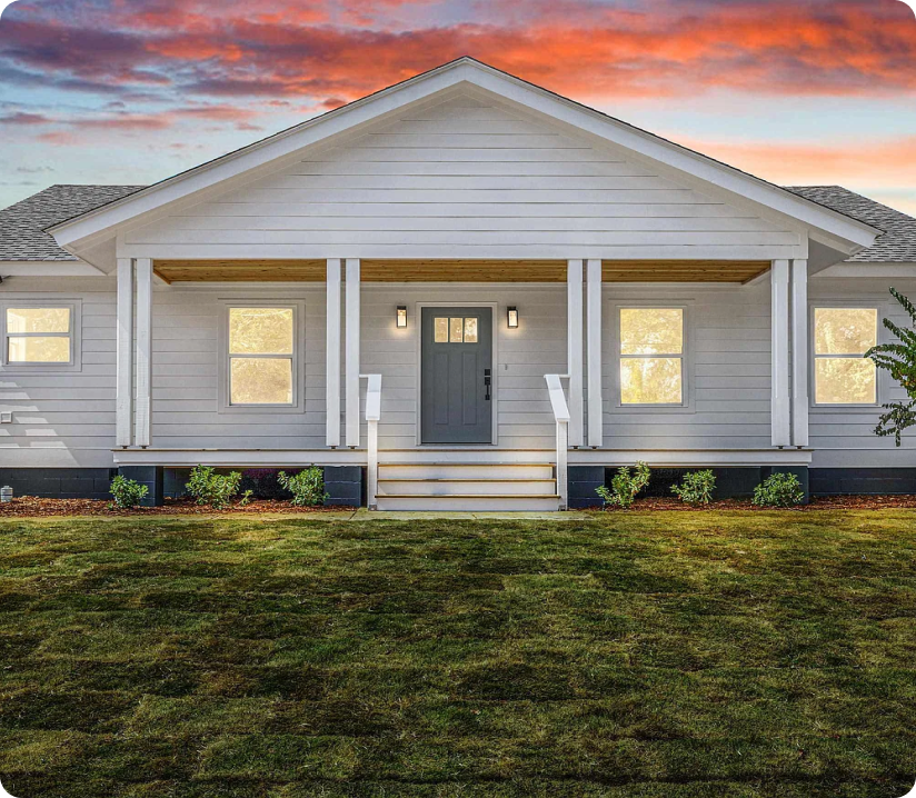 A green front yard and the house on the property at sunset, navigate affordable housing Partners, community development
